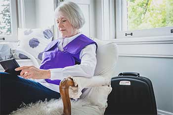 A woman wearing her SmartVest while using a tablet