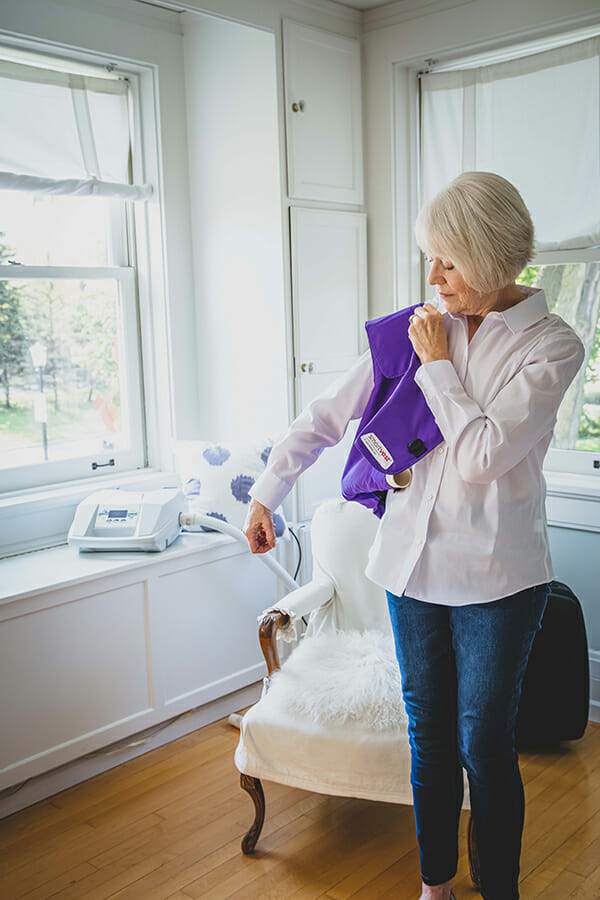 Older woman putting on her SmartVest.
