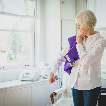 A woman puts her purple SmartVest on