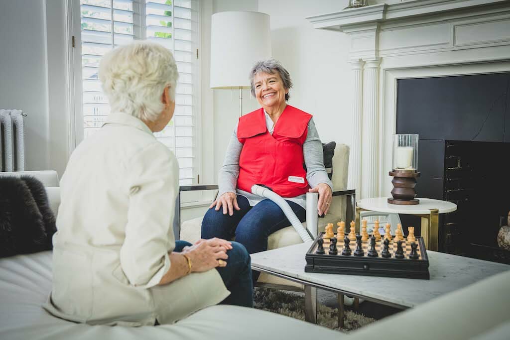 SmartVest user talking to friend while performing HFCWO therapy at home.