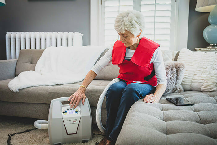 Woman using SmartVest Airway Clearance System.