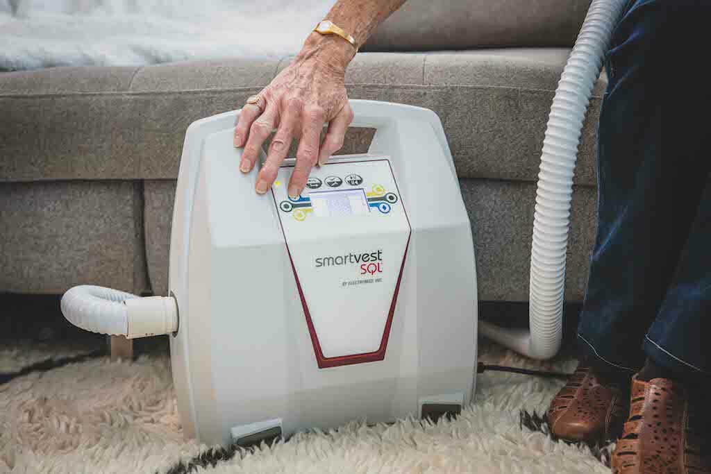 Woman turning on the SmartVest Airway Clearance System's generator.
