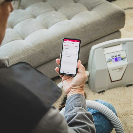 A SmartVest user customizes their therapy using their phone