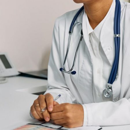 A doctor resting thier hands on a desk