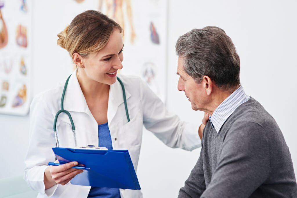 A clinician reviewing the results of a CT scan with COPD patient.