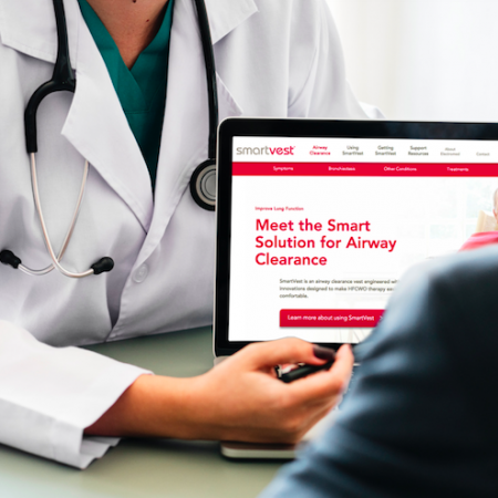 A doctor points to the SmartVest site on their laptop