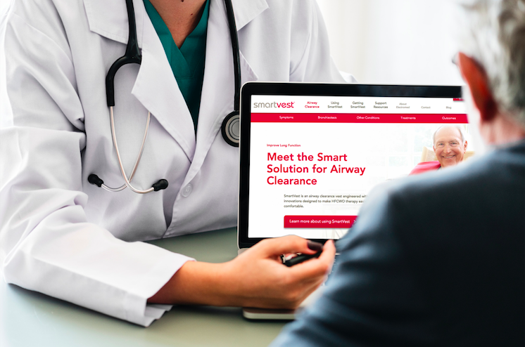 A doctor points to the SmartVest site on their laptop