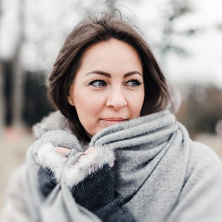 A woman looks over her shoulder while outdoors