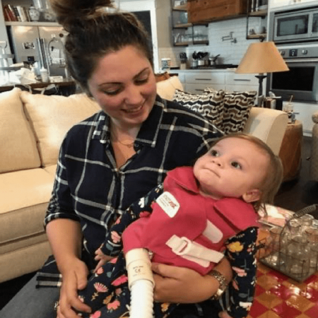 A mother smiles down at her child who is wearing a SmartVest