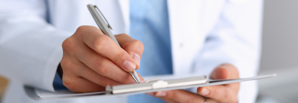 A doctor writing on a clipboard