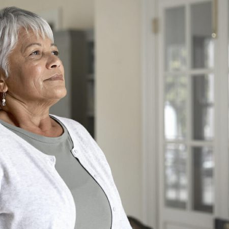 A woman looks out a window
