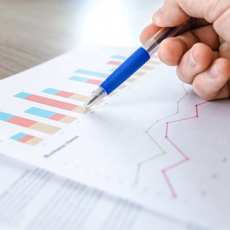 A pen points to graphs on a report