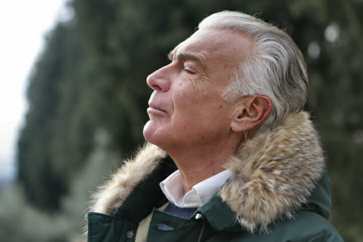 Older man with asthma smelling the fresh air.