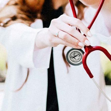A doctor holds out a stethoscope