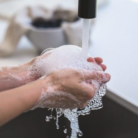 Hands washing eachother under a faucet
