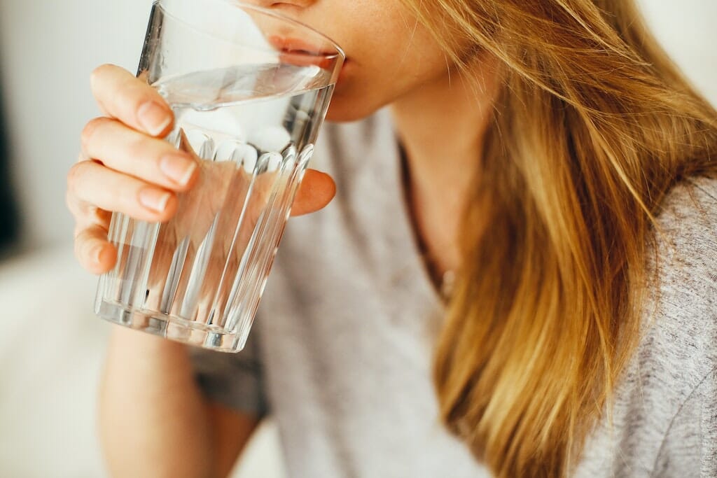 Young woman with COPD drinking glass of water.