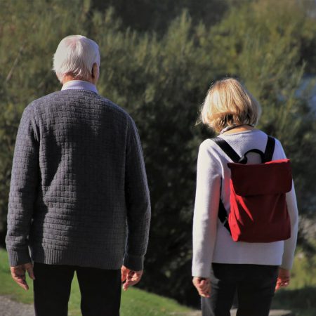 An older couple go for a walk outside