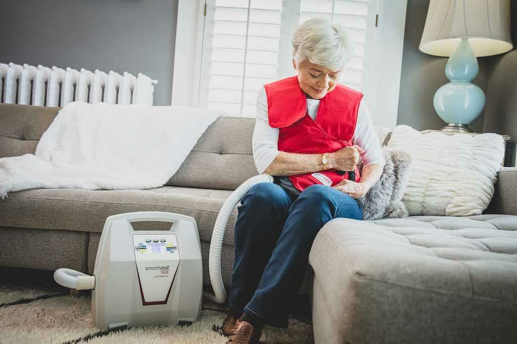 SmartVest user putting respiratory vest on before starting therapy.