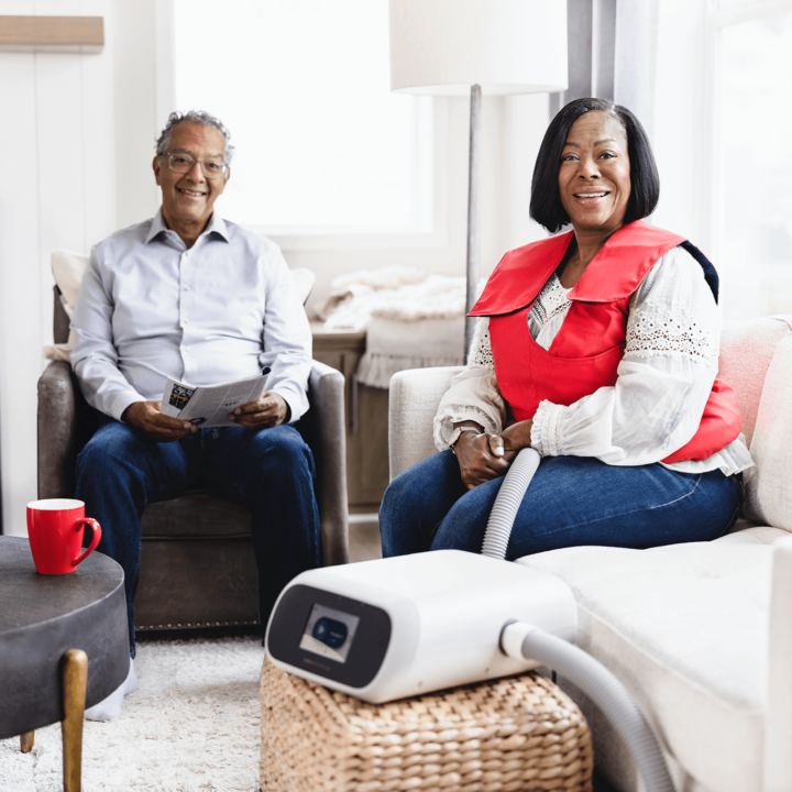A husband and wife sitting together while the wife uses her SmartVest