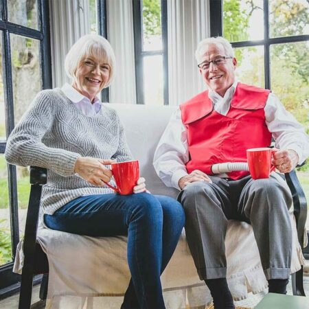 An older couple shares coffee while the man uses his SmartVest