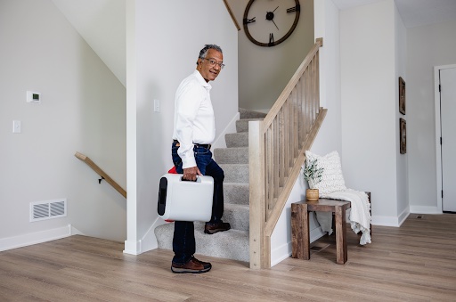 SmartVest patient carrying light-weight generator upstairs.