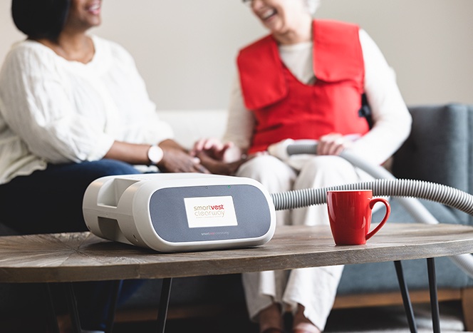 Two SmartVest users sitting on cough talking.