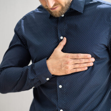 Middle-aged man holding chest wall.
