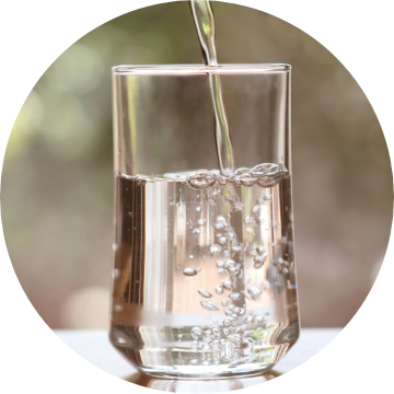 Water pouring into a drinking glass.
