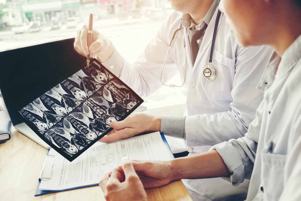Doctor consulting with patient presenting results on x-ray film About the problem of the patient