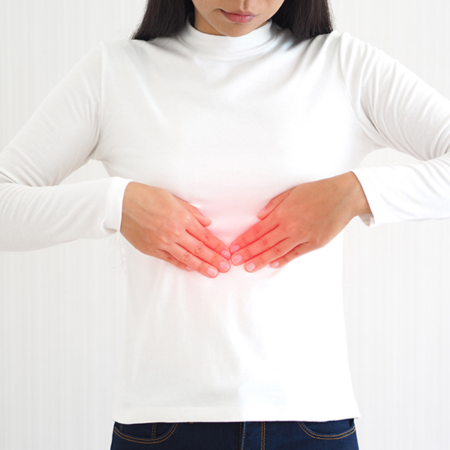 Woman putting two hands over her diaphragm.