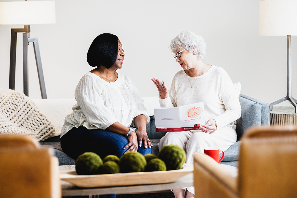 Two older women discussing the benefits of The SmartVest Airway Clearance System.