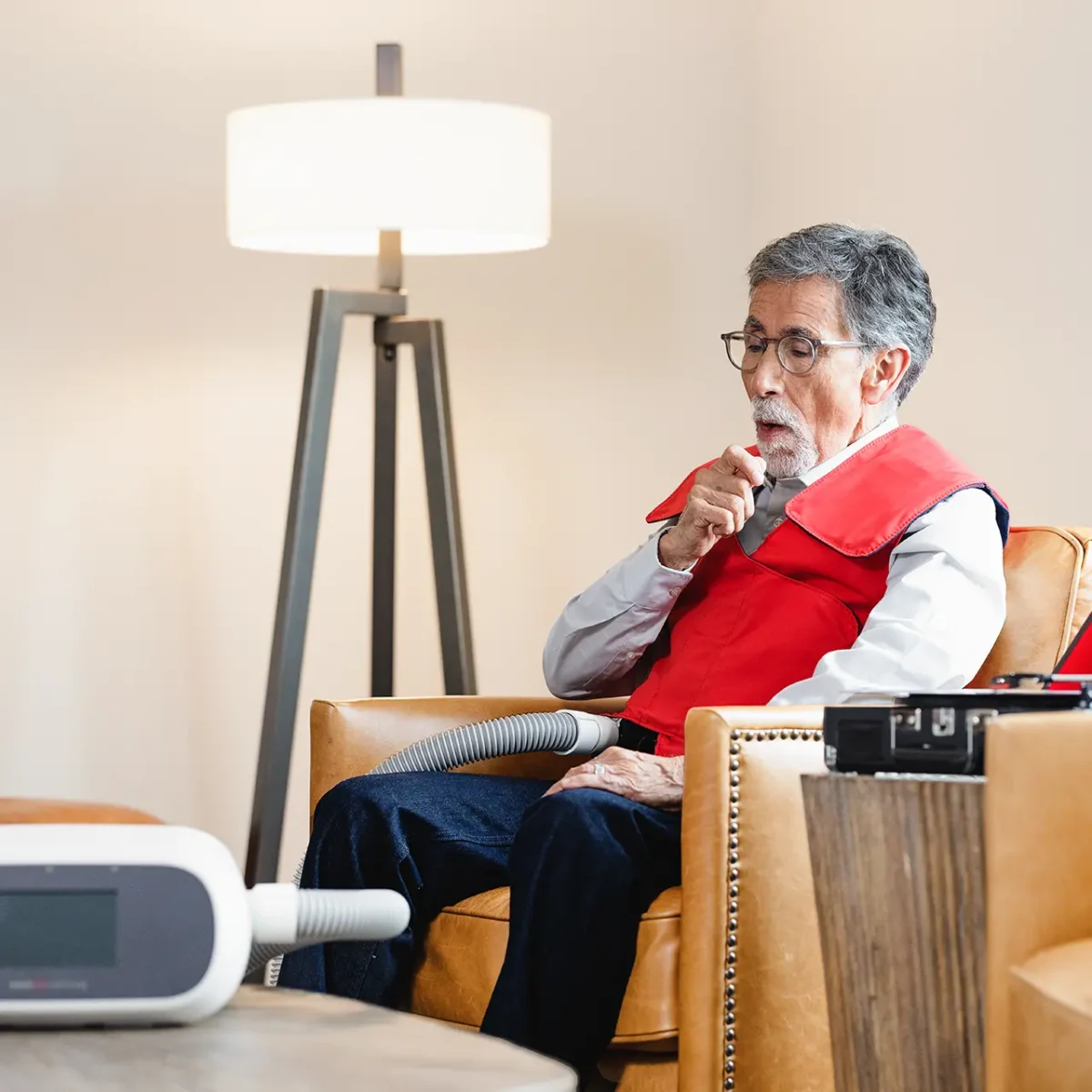 Older man using SmartVest to help clear mucus buildup.