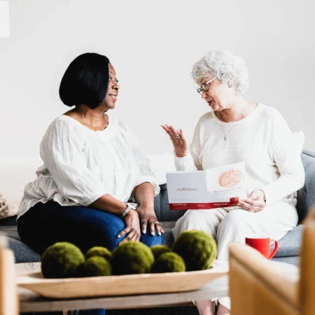 A patient discussing her impaired airway clearance with SmartVest uses her therapy while answering work emails.
